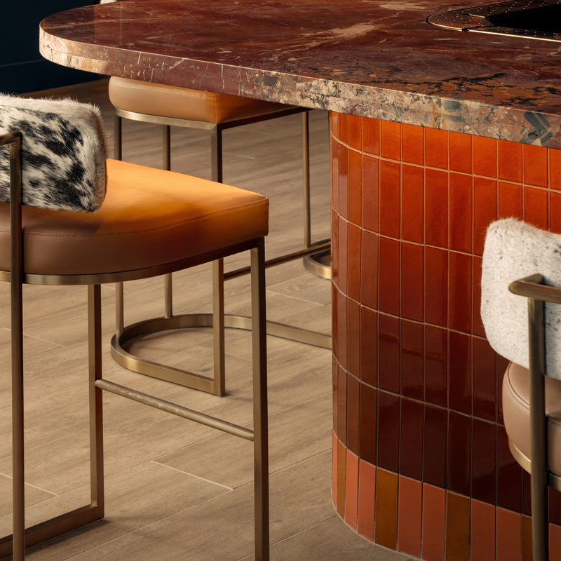 Close-up of genuine cowhide upholstery, handcrafted stitching, and solid wood construction on a luxury bar stool.